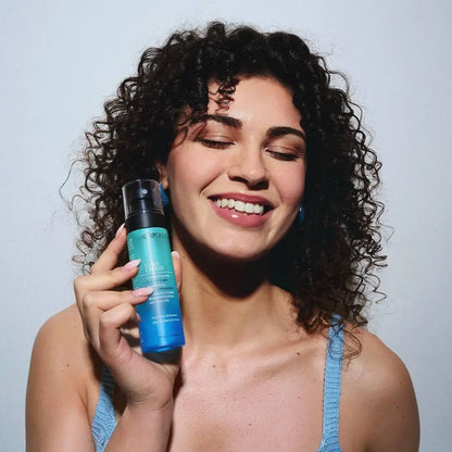 Aurodhea Lush Cloud SBM004 Summer Dream – Frau hält parfümiertes Körperspray und genießt den frischen, fruchtigen Sommerduft