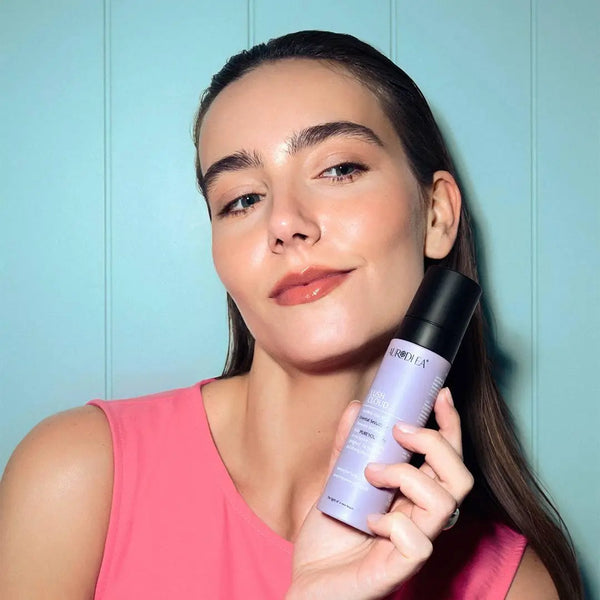 Aurodhea Lush Cloud SHM005 Oriental Seduction – Frau hält Haarparfüm-Spray, gepflegtes Haar, sommerlicher Lifestyle-Look