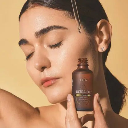Lolûm Ultra Oil Antioxidant & Brightening LO009: Eine Frau trägt das pflegende Öl mit der Pipette auf ihr Gesicht auf.
