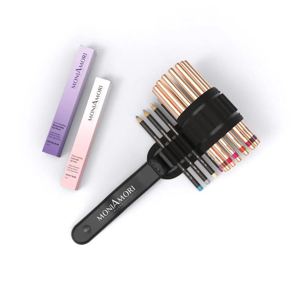 MoniAmori Extra-Stay Set MMKIT01: Schwarze Stifterolle bestückt mit roségoldenen Augen- und Lippenstiften, daneben Einzelverpackungen Extra-EyeStay Crystal Blue (lila/weiße Box) und Extra-LipStay Velvet Taupe (rosa/weiße Box) von MoniAmori Milano auf weißem Hintergrund.
