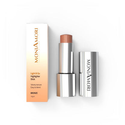 MoniAmori Light & Go Highlighter Stick MM045 Bronze: Geöffneter silberner Highlighter-Stift mit schimmernder, bronzefarbener Textur, daneben die elegante Verpackungsbox mit Farbverlauf und MoniAmori-Logo, auf weißem Hintergrund.
