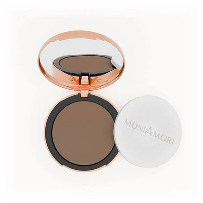 MoniAmori Solar Defence Compact Foundation MM009 Tiramisù: Geöffnete roségoldene Puderdose mit Spiegel, die den dunkelbraunen Foundation-Ton zeigt, daneben der weiße Schwamm-Applikator mit MoniAmori-Logo, auf weißem Hintergrund.