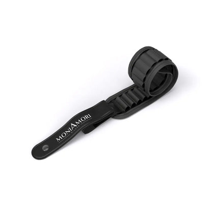 MoniAmori Stifterolle MM036 leer eingerollt: Schwarze Stifterolle aus elastischem Material mit MoniAmori Milano-Prägung auf dem Lederband, auf weißem Hintergrund.